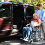 men helping the elderly in wheelchair